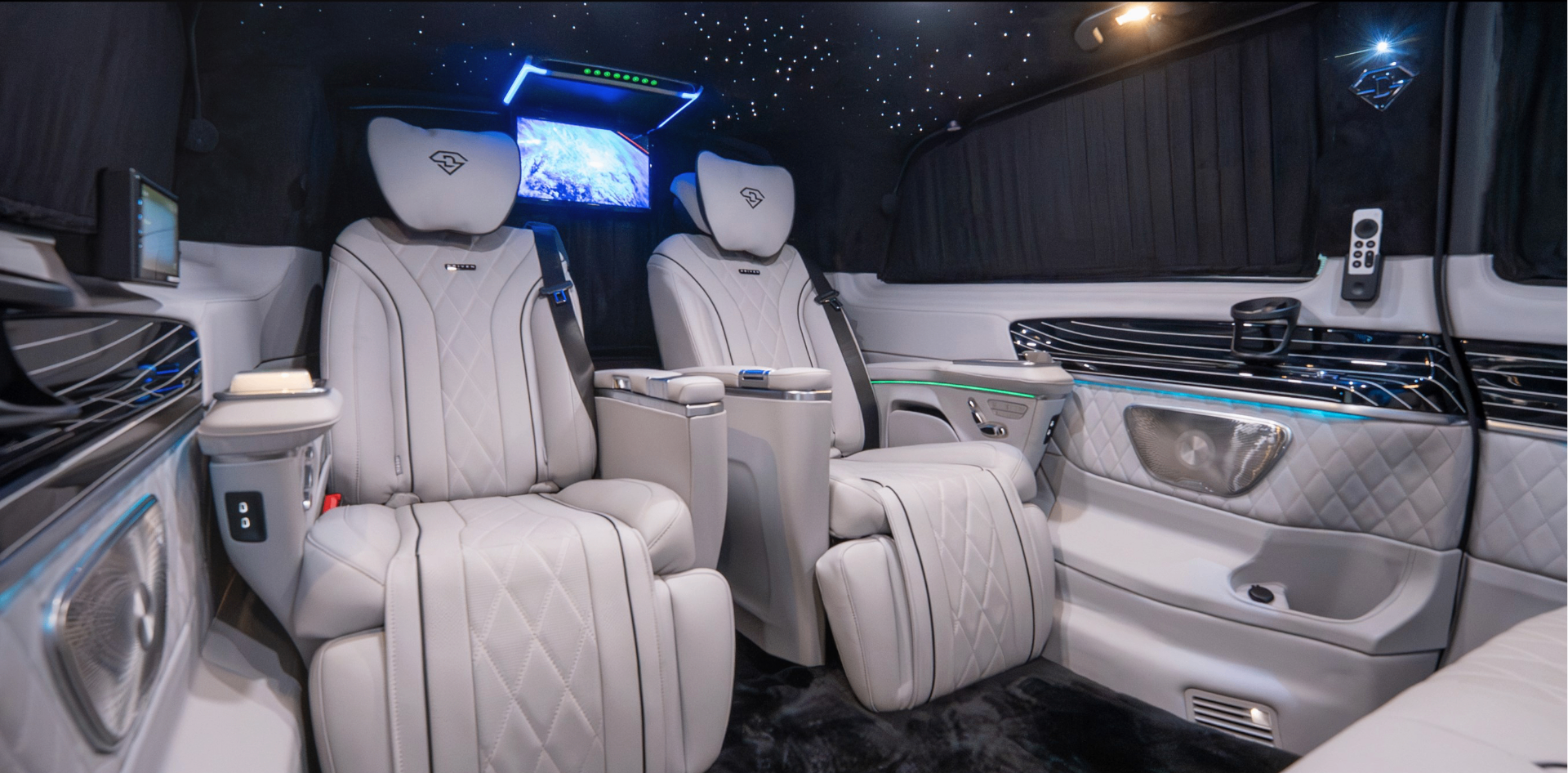Rear cabin of the Land Jet with reclining captain seats, star-lit headliner and overhead screen